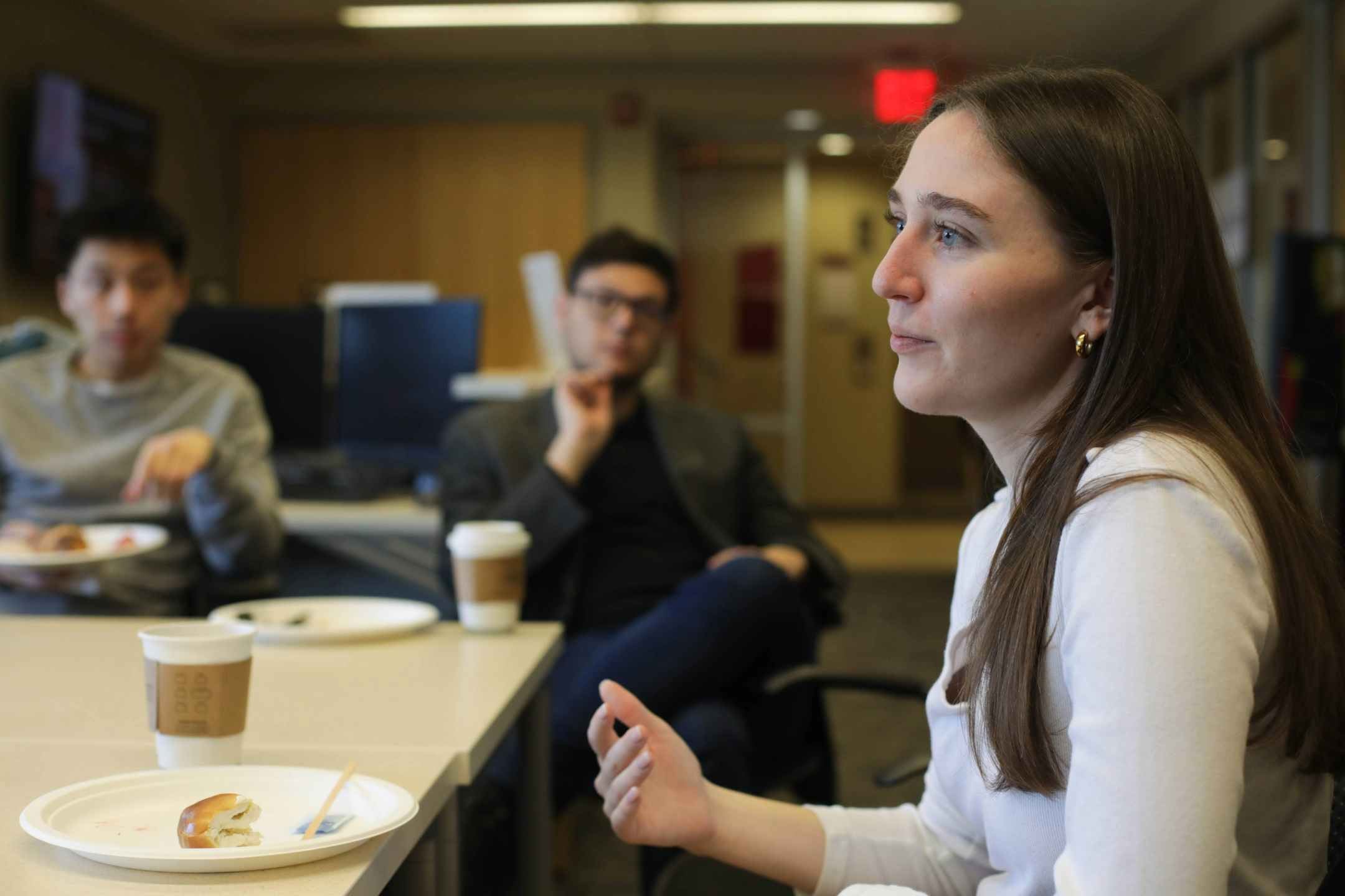 Grace Van Hollebeke &rsquo;19 (CALS) speaks at a table with two people visible in the background.