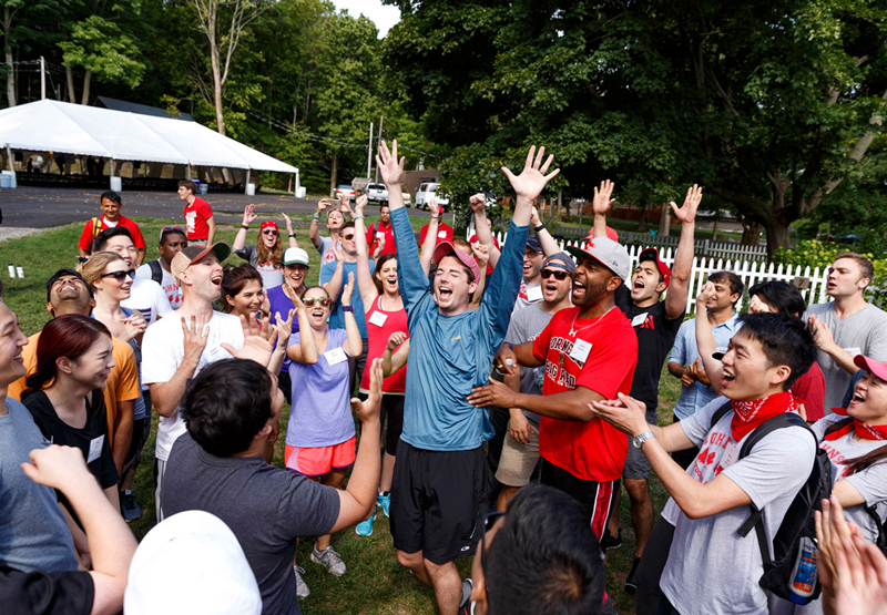 A group of Cornell volunteers cheer with their hands in the air