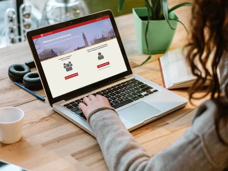 A person accesses the Cornell alumni directory on their laptop.