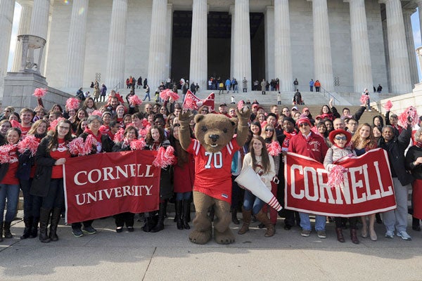 Touchdown stands with a crowd of people holding Cornell banners