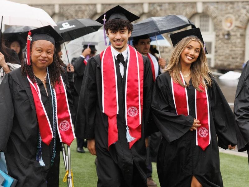 Three new graduates smiling after completing graduation.